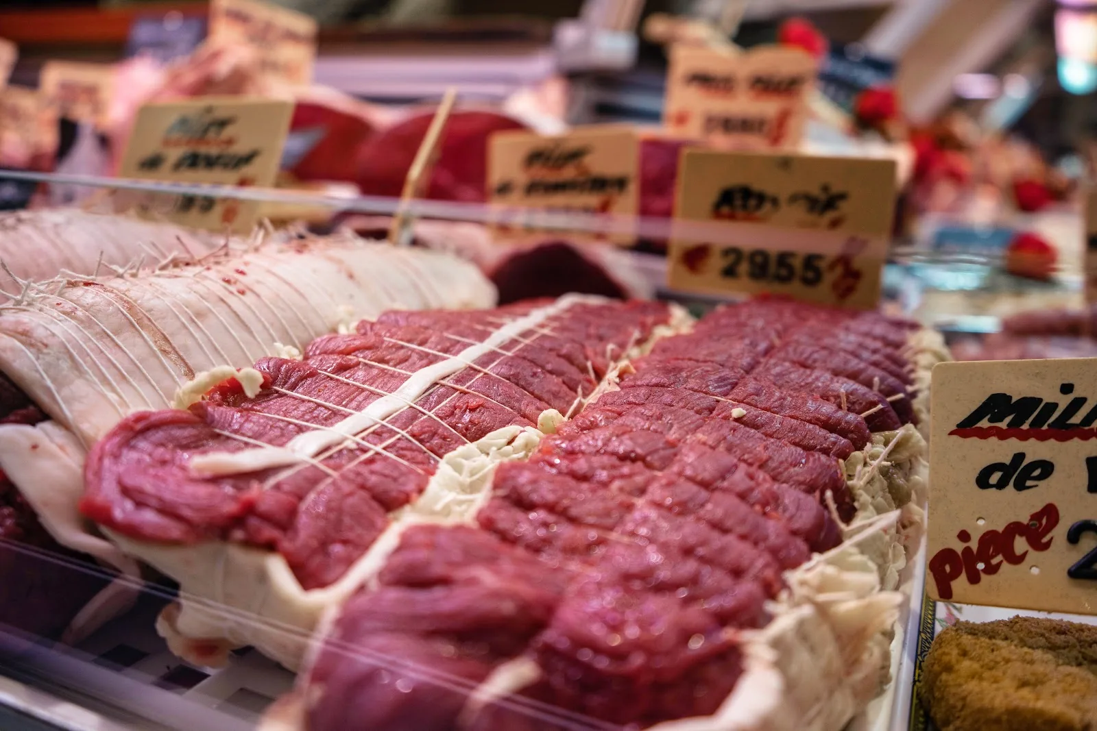 L'étal de la boucherie, rôtis parés et ficelés, étiquettes écrites à la main